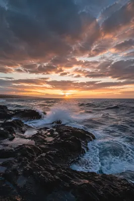 Sunrise Waves Crashing on Rugged Shoreline Rocks