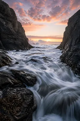 Sunrise Waves Crashing Through Rocky Cove