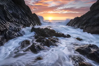 Sunrise Waves Through Rocky Coastal Cove