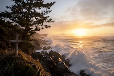 Evergreen Cross Above Crashing Sunrise Waves