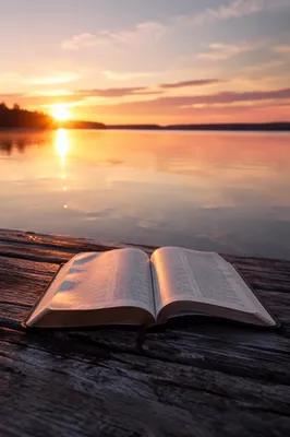 Open Bible by Lakeside Sunset