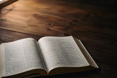 Open Bible on Walnut Table