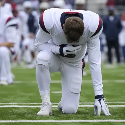 Athlete Kneeling in Prayer on Turf