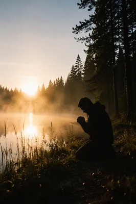 Silhouetted Prayer Beside Misty Evergreen Lake
