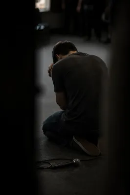 Person Kneeling in Prayer Indoors