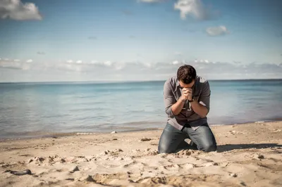Kneeling Prayer on Peaceful Sandy Shore