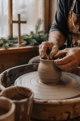 Potter Hands Shaping Clay with Evergreen Cross