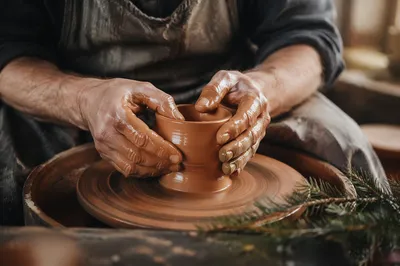 Potter Hands Shaping Clay with Evergreen Hope