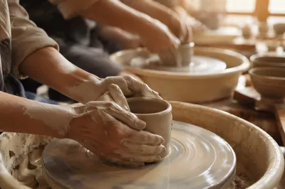 Hands Shaping Clay in Sunlit Fellowship Studio
