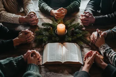 Prayer Group Hands Around Evergreen Candle