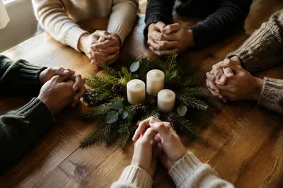 Prayer Group Hands Around Evergreen Table