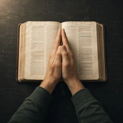 Praying Hands Over Open Bible