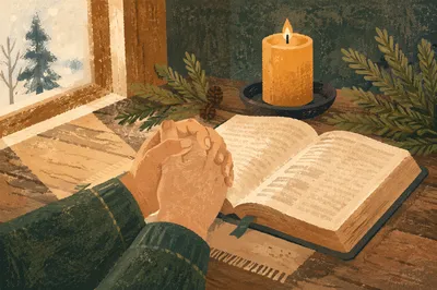 Praying Hands Beside Bible with Evergreen