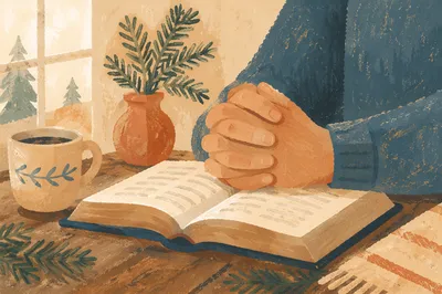 Praying Hands Over Bible with Evergreen Sprigs