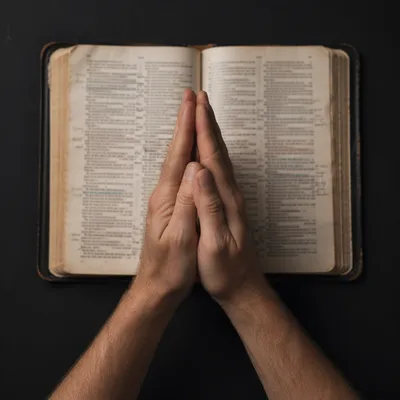 Praying Hands Over an Open Bible