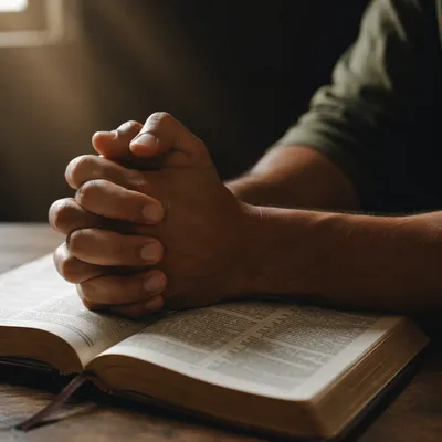 Praying Hands Resting on Open Bible