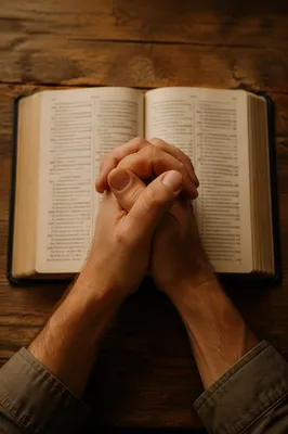 Praying Hands Over Open Bible