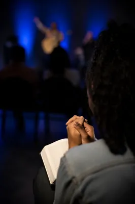 Praying Hands Over Open Bible