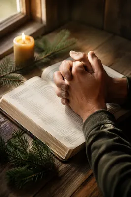 Praying Hands Over Open Bible