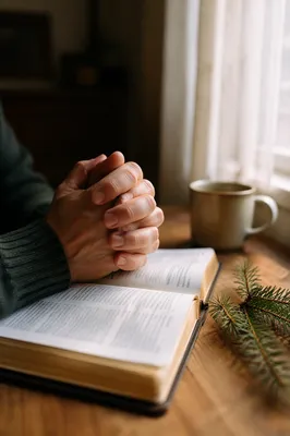 Praying Hands Above Open Bible