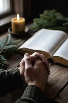 Praying Hands Beside Open Bible