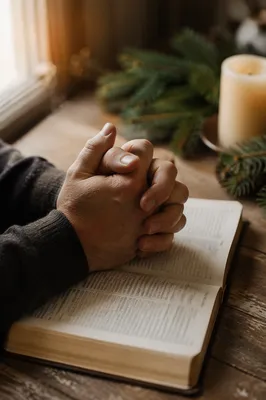 Praying Hands Over Open Bible