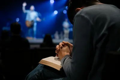 Praying Hands Over Open Bible