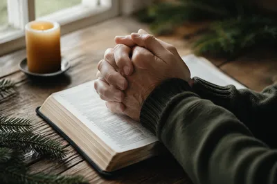 Praying Hands Over Open Bible