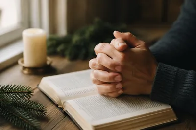 Praying Hands Over Open Bible