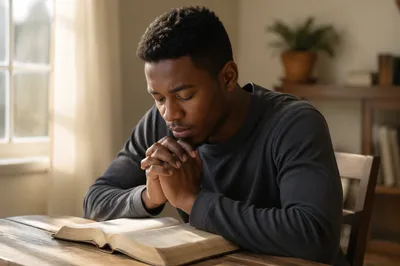 Young Man Praying Over Open Bible