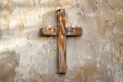 Rugged Wooden Cross on Aged Plaster Wall