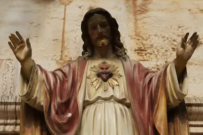 Classical Devotional Statue Against Stone Wall