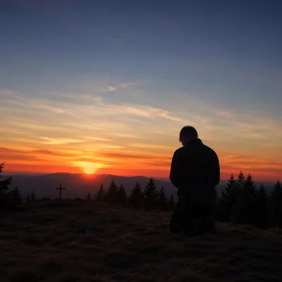 Silhouetted Prayer on Evergreen Sunset Hilltop