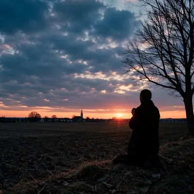 Silhouette Praying at Rural Sunset Sky