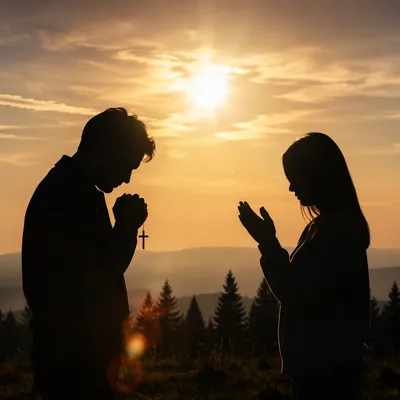 Silhouettes Praying at Sunset Hillside