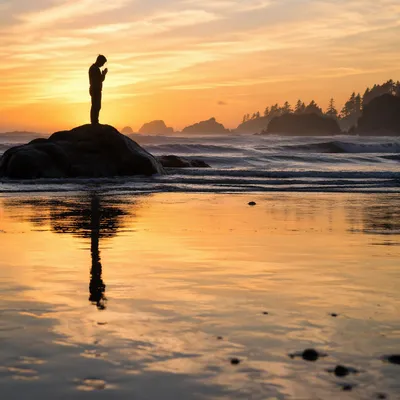 Praying Silhouette on Coastal Sunset Shore