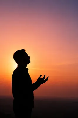Praying Silhouette in Peaceful Sunset Sky