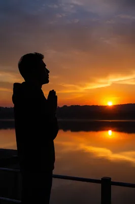 Silhouette Prayer by Lakeside Sunset