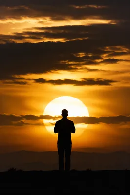 Praying Silhouette Beneath Golden Sunset Sky