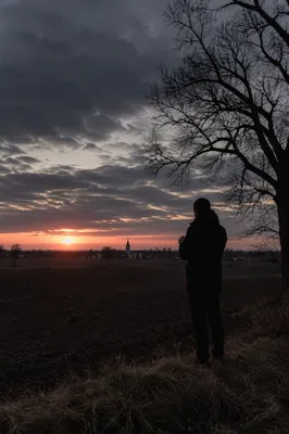 Silhouette Praying at Rural Sunset Sky
