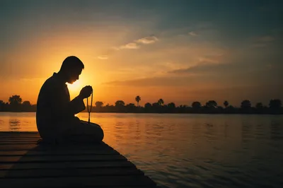 Praying Silhouette on Dock at Sunset