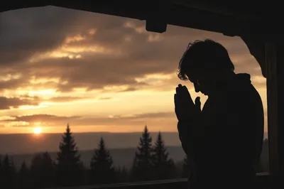 Silhouetted Prayer Beneath Sunset Sky