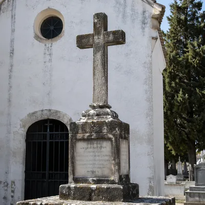 Weathered Stone Cross by Whitewashed Chapel