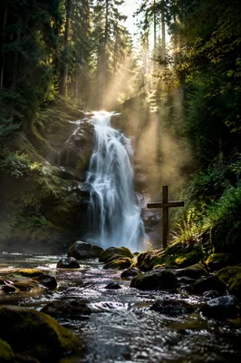 Evergreen Waterfall with Quiet Wooden Cross