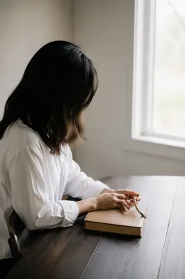 Woman Reading Bible Beside Bright Window