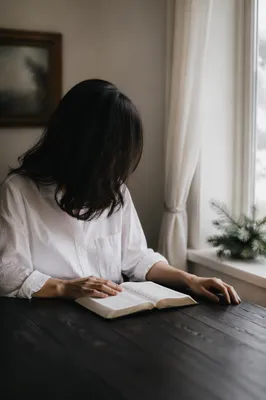 Woman Reading Bible by Bright Window
