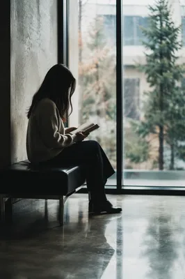 Woman Reading Bible by Bright Window