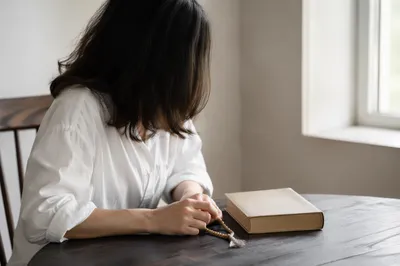 Reflective Woman with Bible by Bright Window
