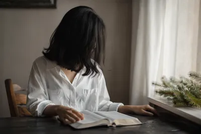 Woman Reading Bible by Sunlit Window