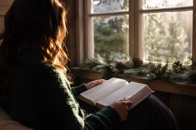 Woman Reading Bible by Frosted Cottage Window